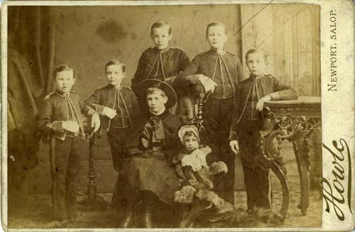 Family portrait showing 7 young boys all in matching military style uniform.