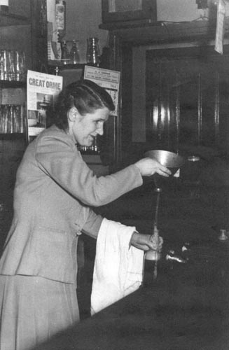 Mrs Ada Perry filling up a bottle of beer for the off-license trade.